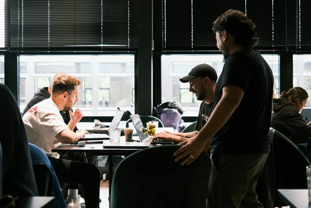 pexels-photo-18678225-18678225 Smiling Men Working on Laptops on Table